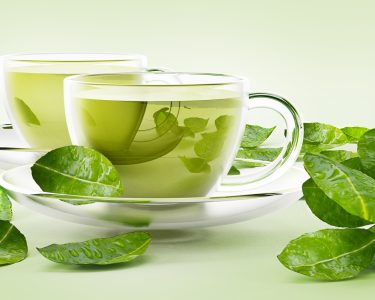 Glass cups with green tea and tea leaves isolated on white.